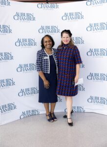Attendees gathered at the Auburn Chamber of Commerce annual meeting, engaging in conversations and networking in a professional setting.
