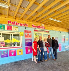 Pelican’s SnoBalls ribbon-cutting ceremony in Opelika, AL, featuring a welcoming, family-friendly atmosphere with fun games for kids and delicious snowballs, including the popular Red Velvet flavor