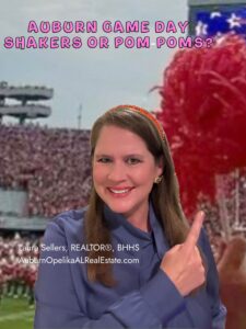 Auburn fans waving orange and blue shakers and pom poms during football game day at Jordan-Hare Stadium.
